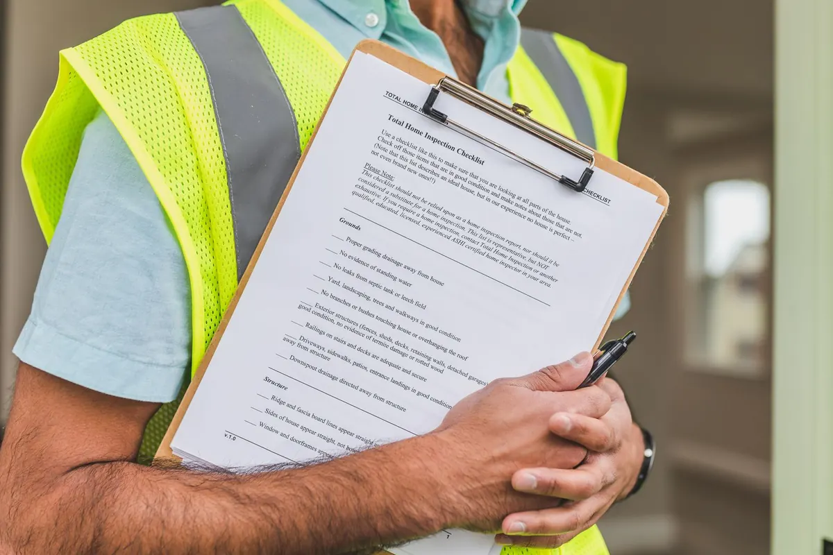 Inspector holding a property inspection checklist on a clipboard